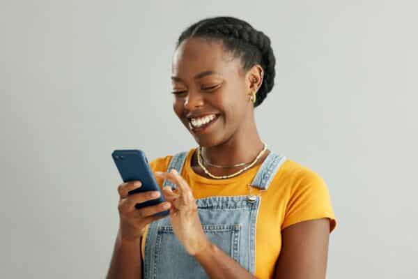 A woman smiling at her phone