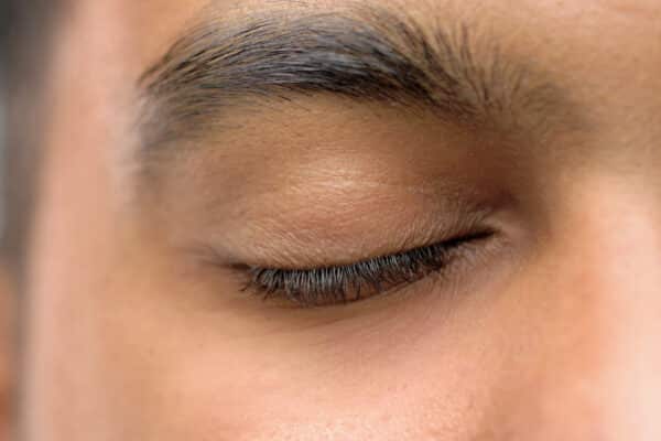 Closeup of man's closed eye, eyebrow and eyelashes