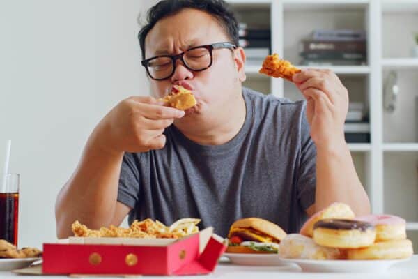 Man eating ultra-processed fast-food and junk food