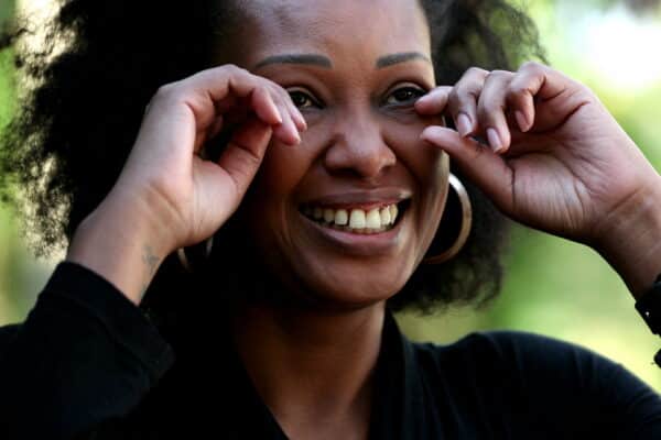Happy woman wiping tears with fingers