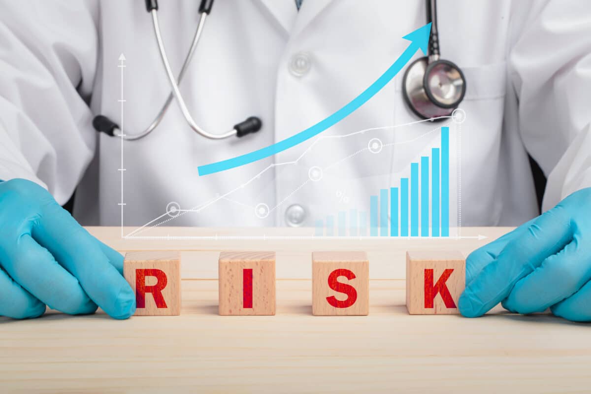 A doctor spelling “risk” with blocks