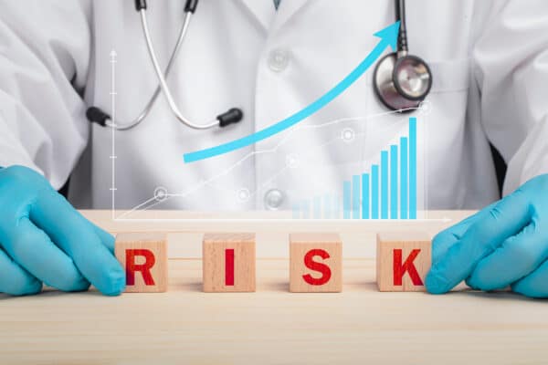 A doctor spelling "risk" with blocks