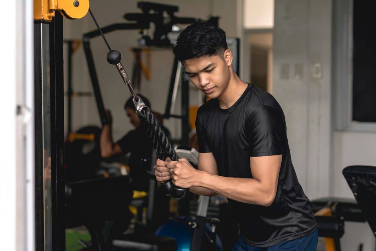 Teen lifting weights and exercising at the gym
