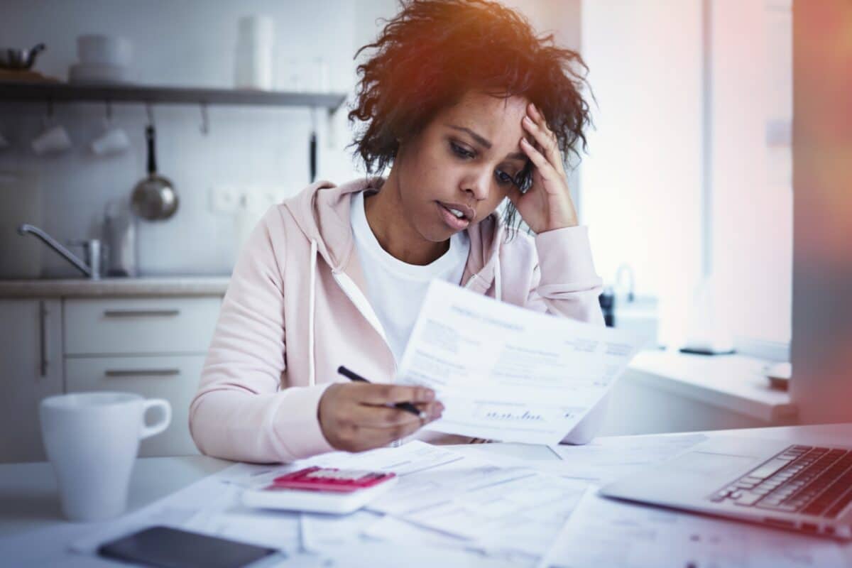 Woman in financial stress looking at bills