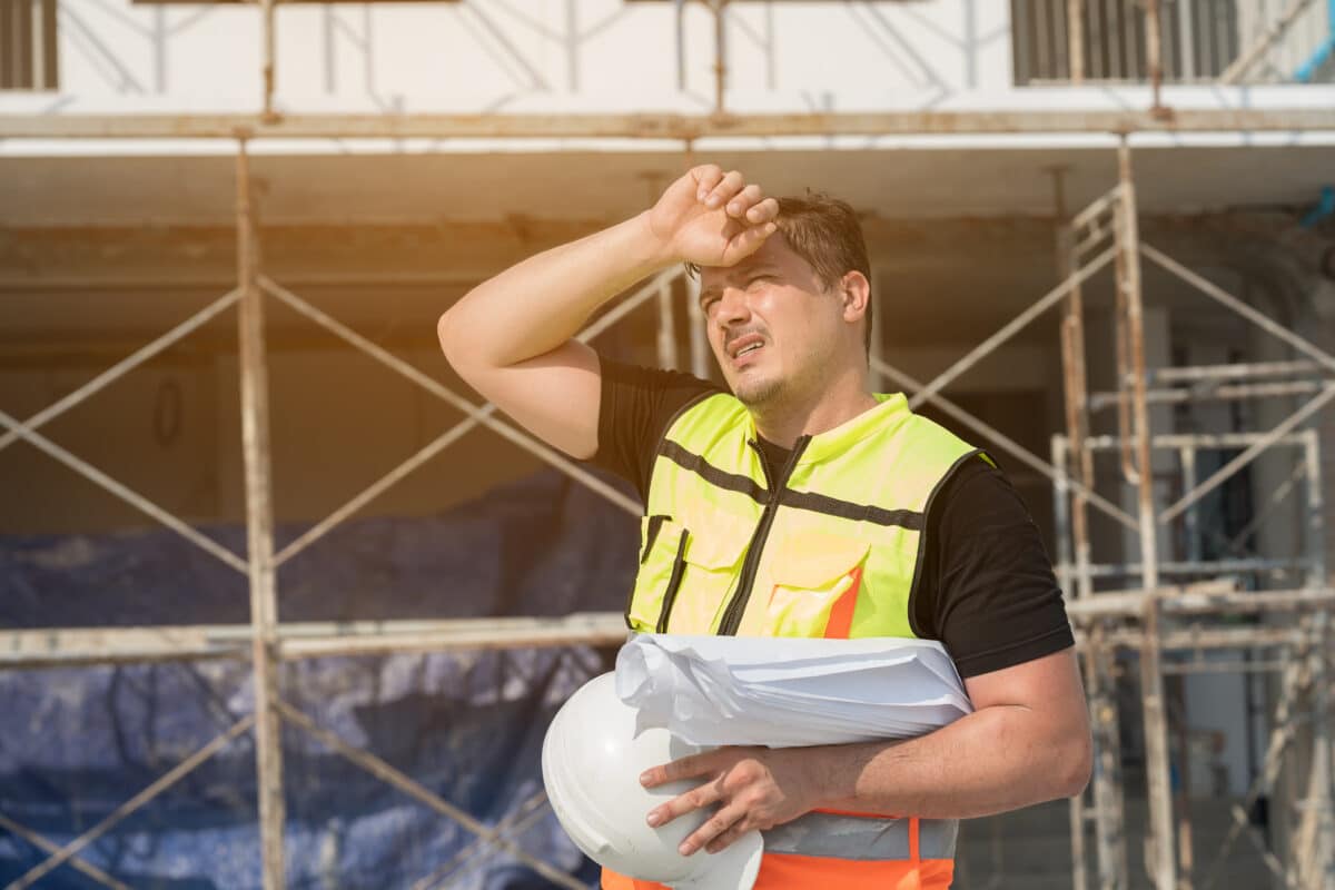 Construction worker wiping sweat on a hot summer day