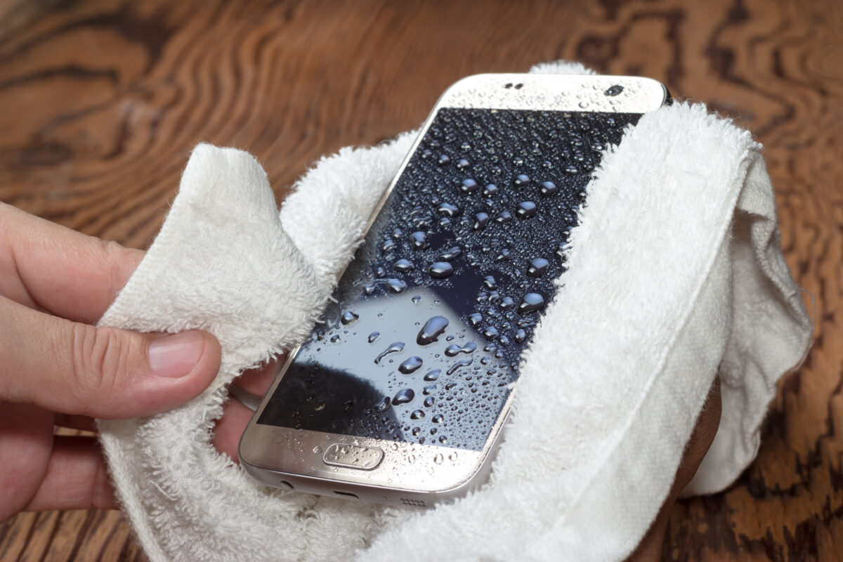 Person dries off a smartphone that fell in water