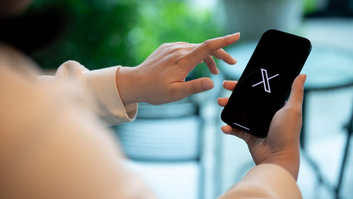 Woman using X app on smartphone
