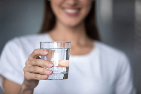 A woman holding a glass of water