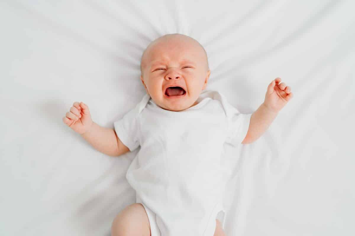 Newborn baby or infant crying in crib