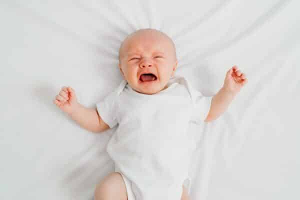Newborn baby or infant crying in crib