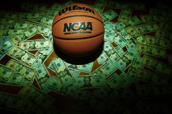 An NCAA basketball surrounded by cash