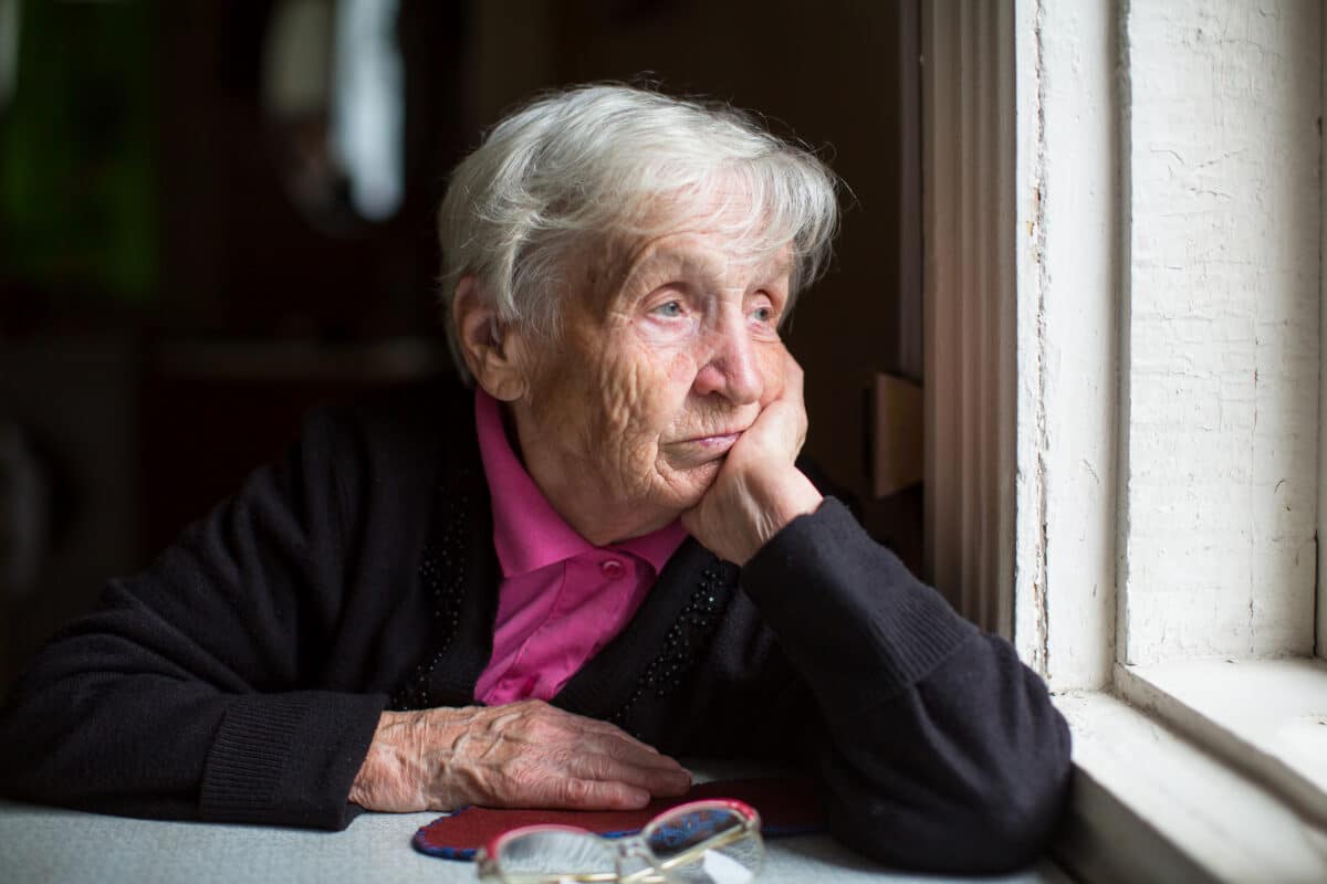Elderly woman looking out the window