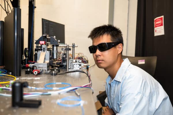 Yichi Zhang, a doctoral student in Materials Science and Engineering, inspects the source of the quantum signal.