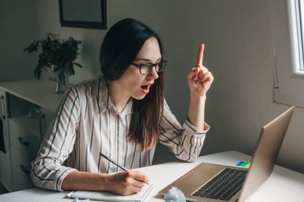 A woman has a "Eureka" moment bright idea while doing work