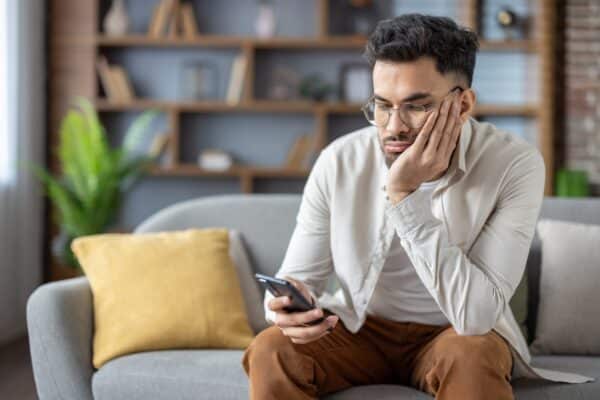 Bored man doomscrolling on his smartphone