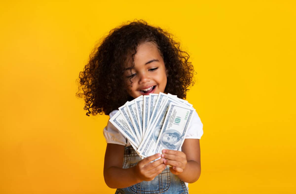 Child holds wad of cash