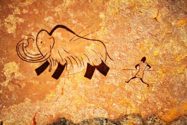 Cave painting of primitive man hunting for mammoth