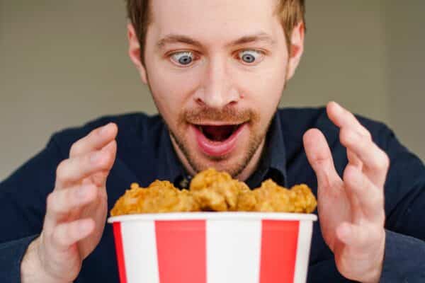 Hungry man excited over bucket of fried chicken