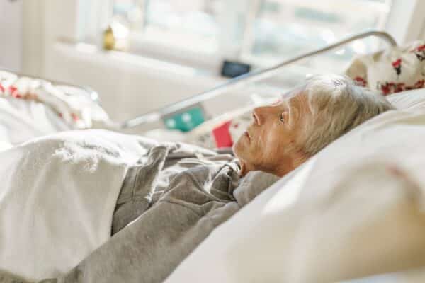 Dying elderly woman alone in her hospice room