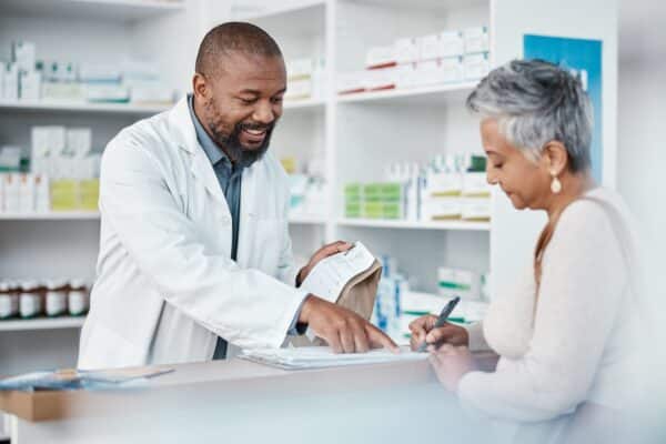 Pharmacist giving prescription drugs to patient at the pharmacy