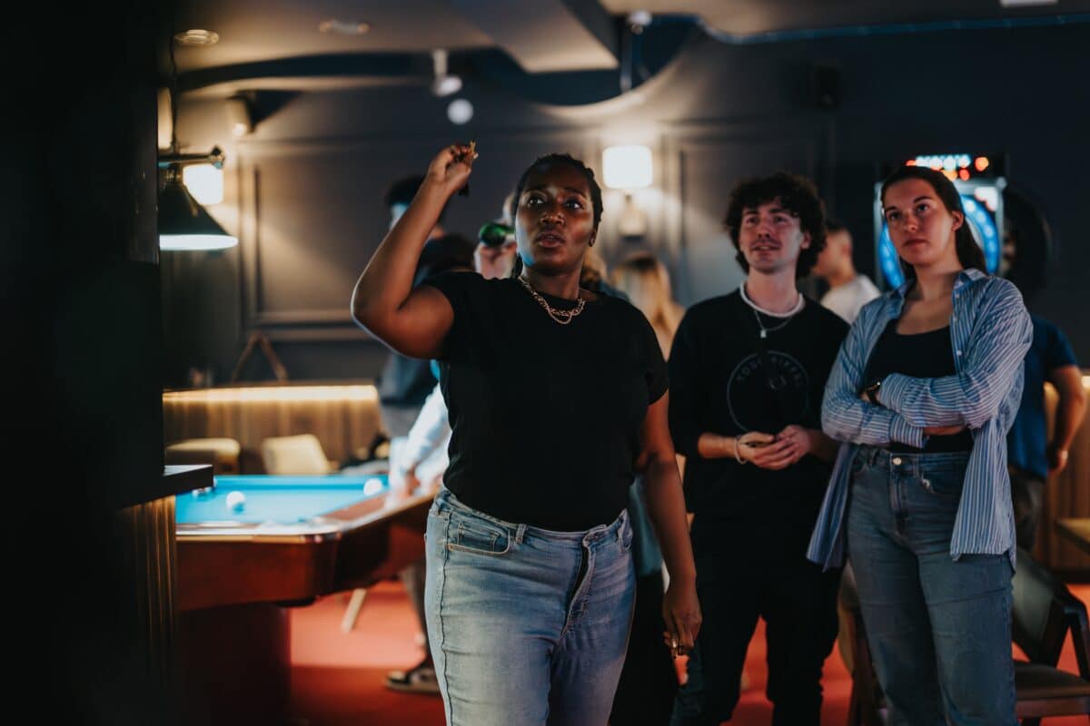 Friends playing a game of darts at the bar