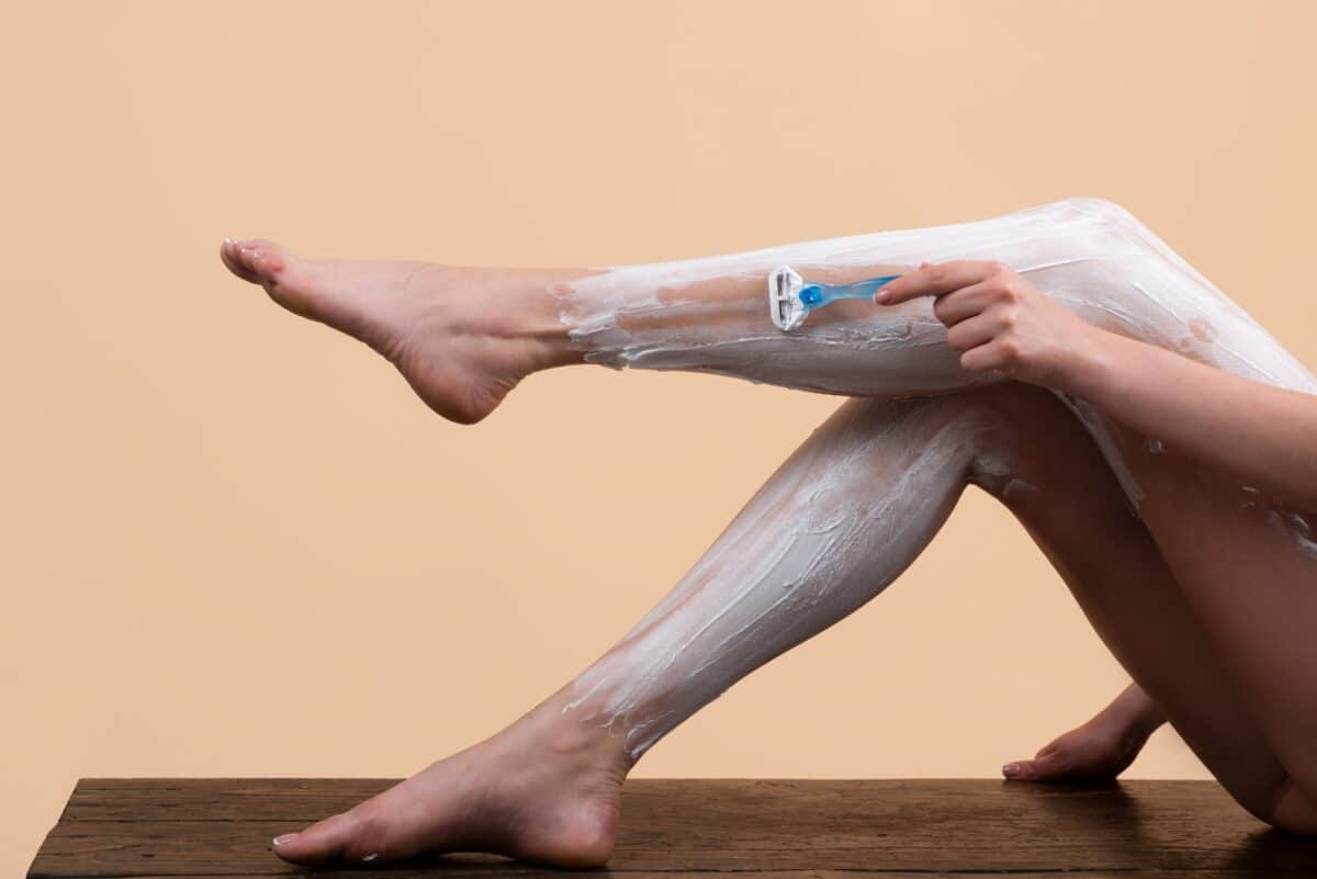 Woman shaving her legs with razor blade