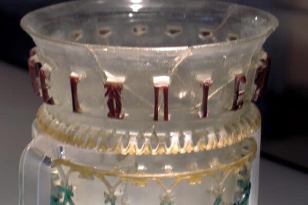 Glass openwork vessel from 300-350 CE with inscription and symbol.