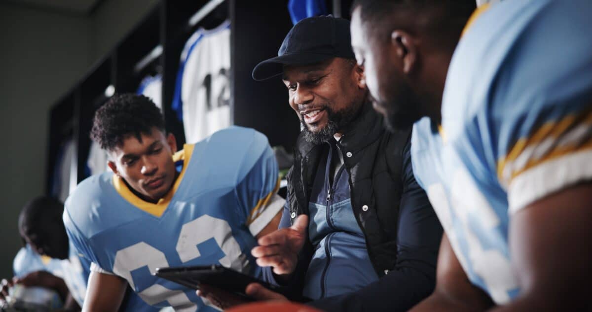 A coach speaking with football players