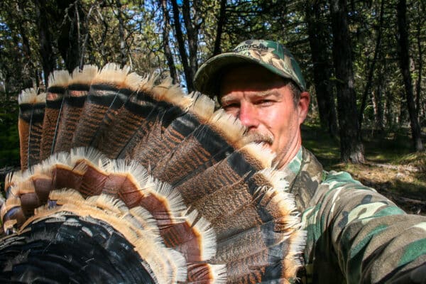 A turkey hunter shows the fan tail of a Tom bird.