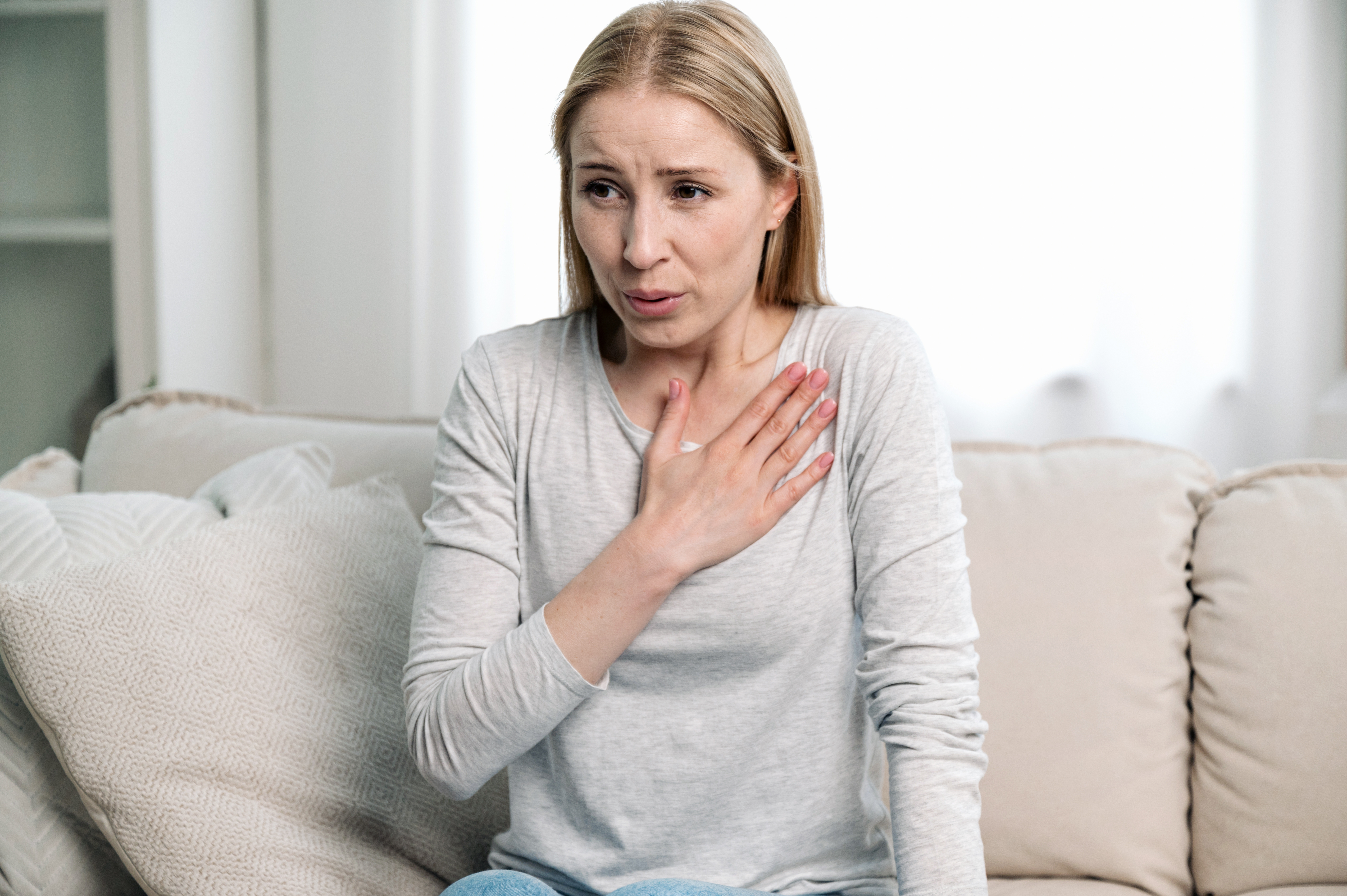 Worried, anxious woman having breathing problem or panic attack