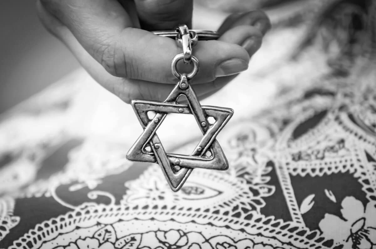 Young woman's hand holding a Star of David (Magen David) key chain.