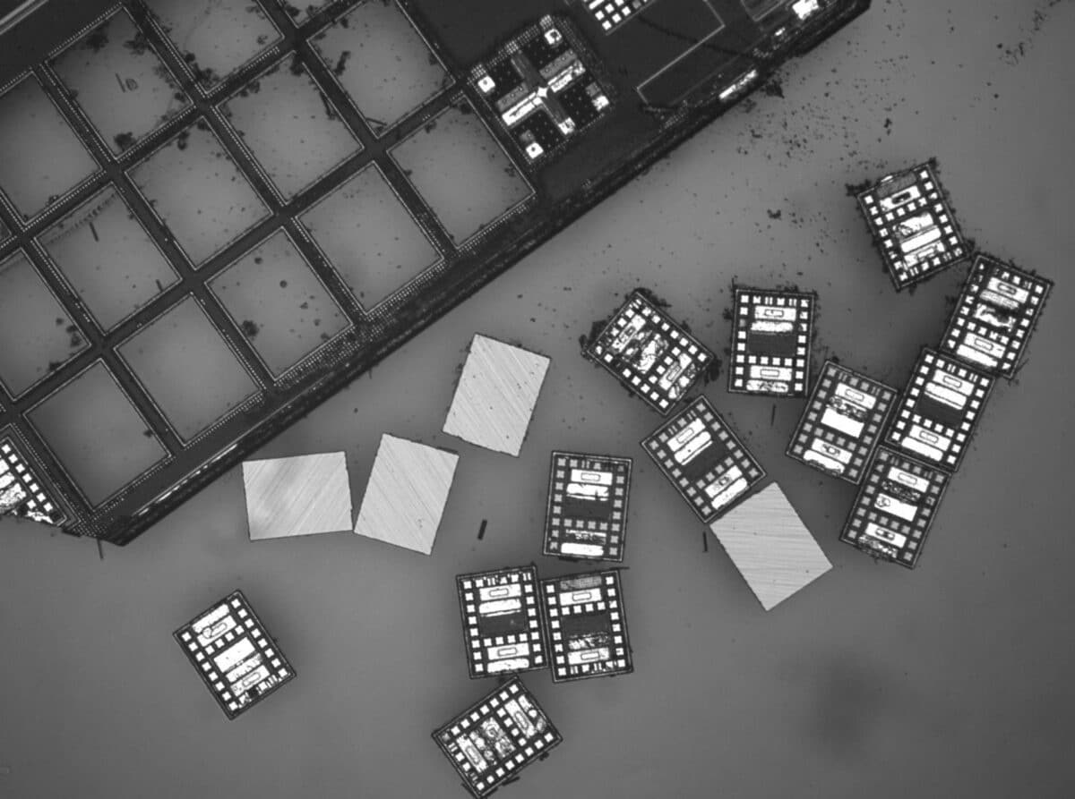 The robots appear black and silvery gray in the grayscale image, with tiny gray squares and rectangles on one side and plain gray on the back.