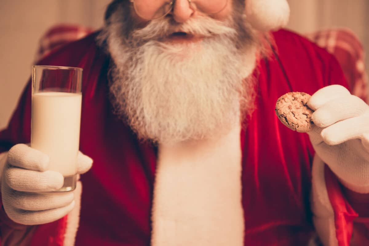 Santa Claus eating a cookie with milk on Christmas