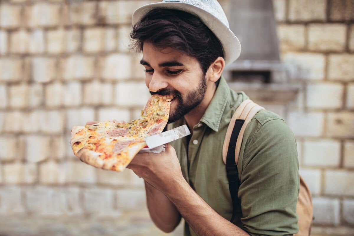 Man eating a huge piece of pizza
