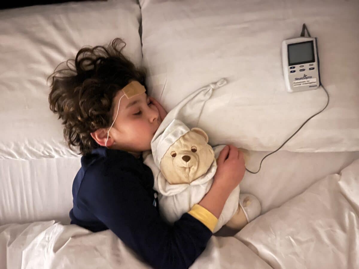 Sleeping child with trigeminal nerve stimulation device for ADHD.