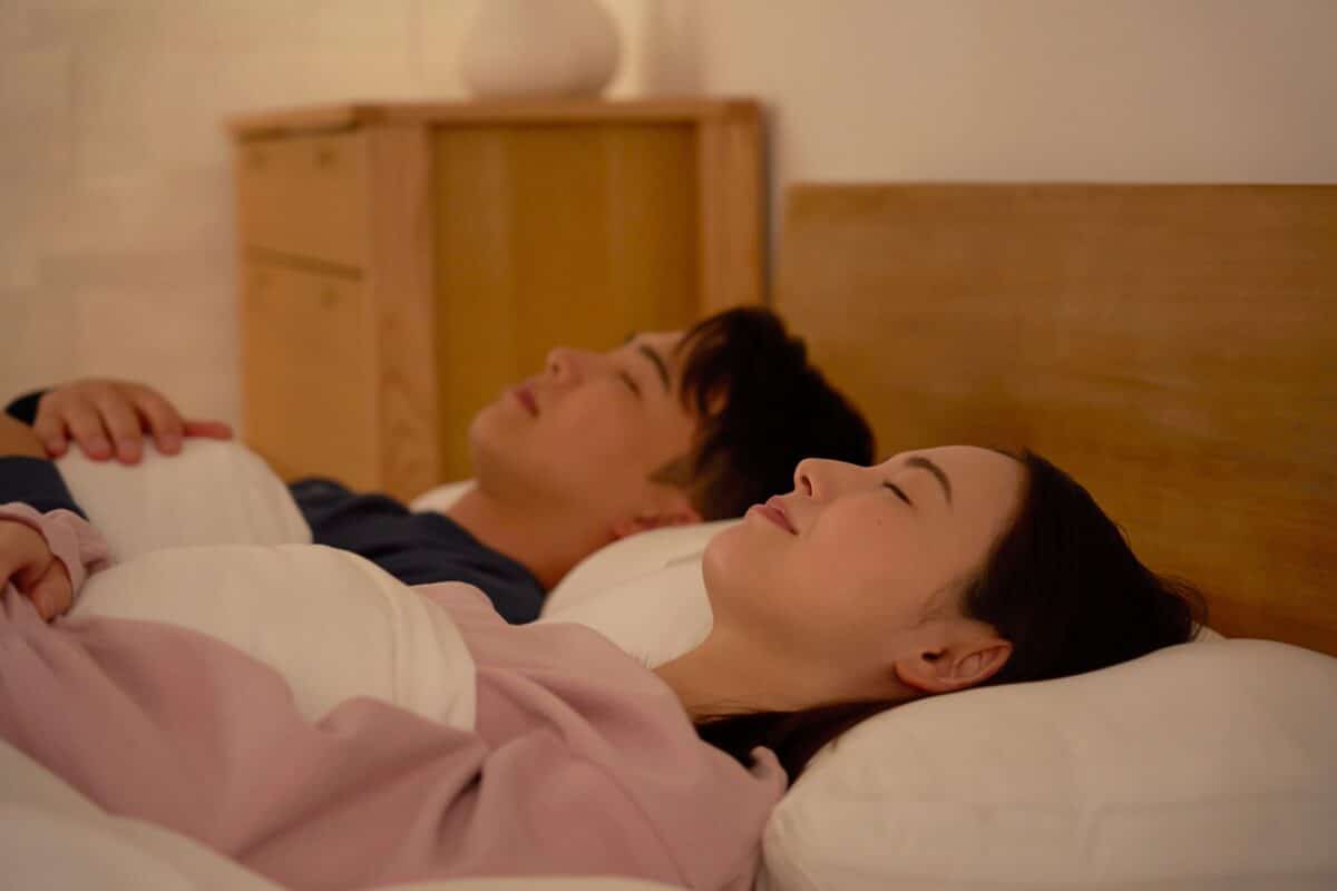 Asian,Couple,Sleeping,In,Bed