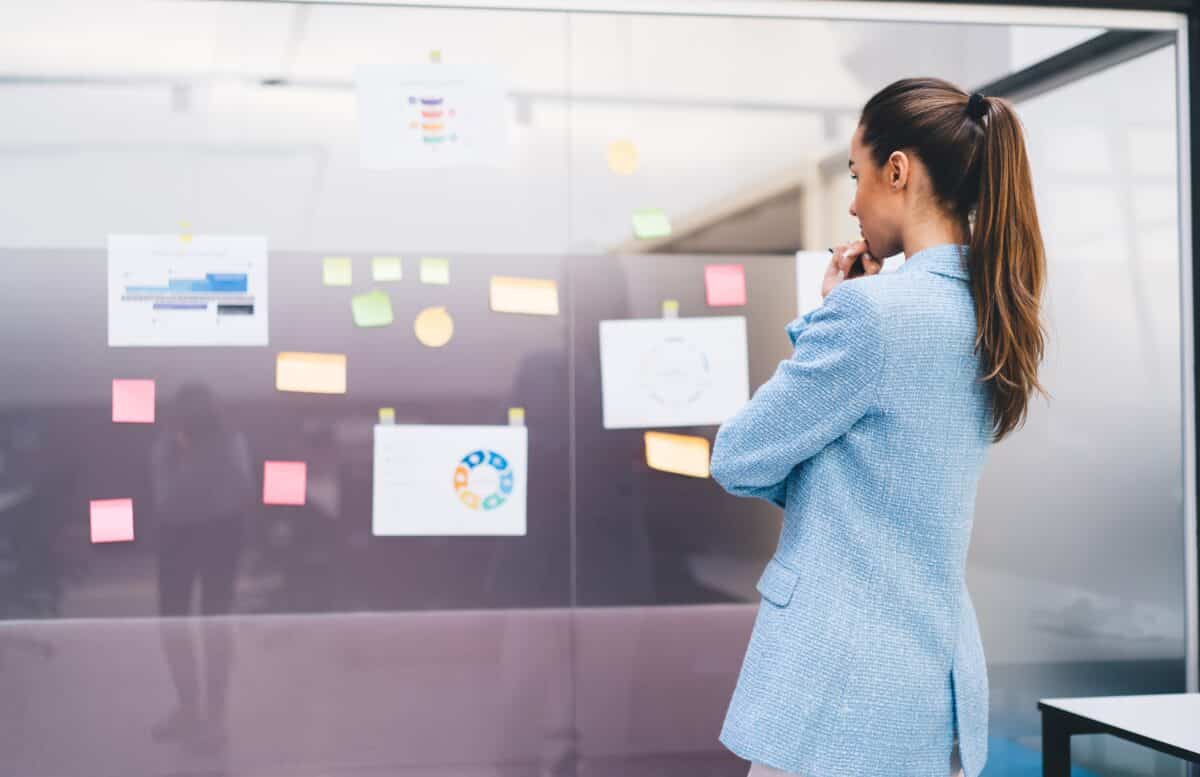 Female,Freelancer,Analyzing,Project,Notes,On,Planning,Wall,,Captured,In