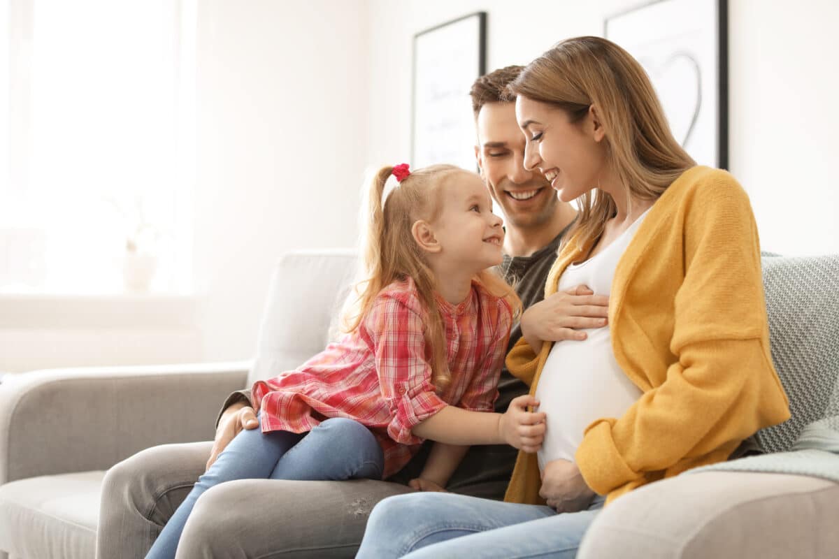 Young,Pregnant,Woman,With,Her,Family,At,Home