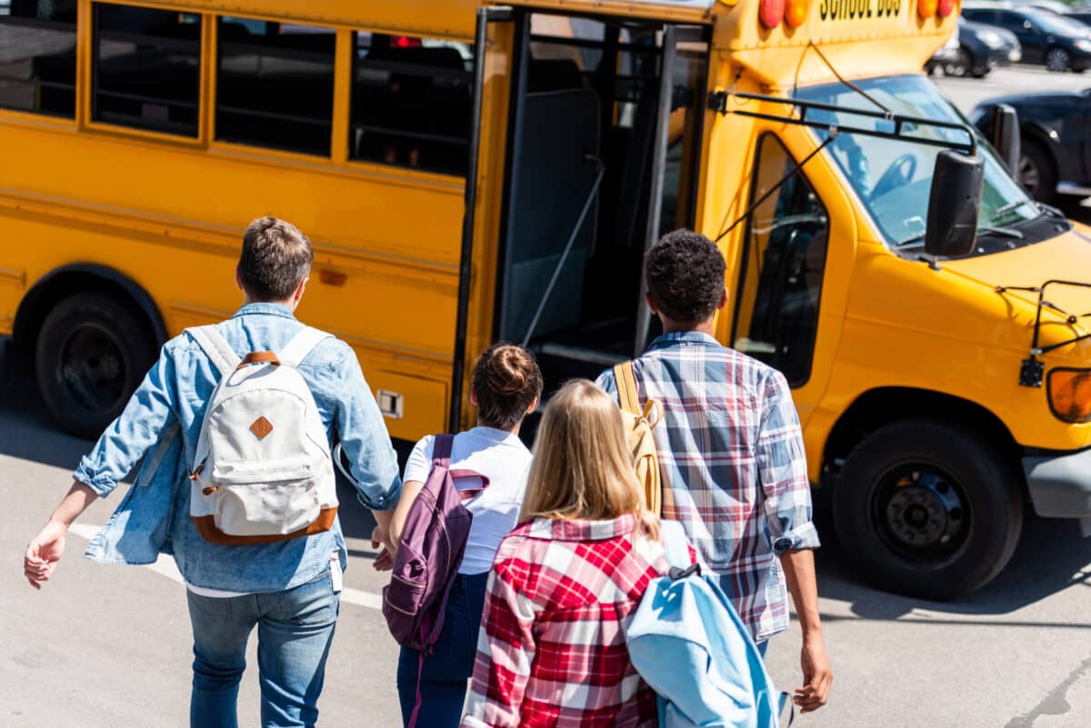 Rear,View,Of,Group,Of,Teen,Students,Walking,To,School