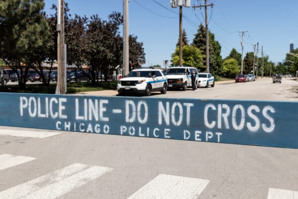 Chicago police use a wooden barrier to block off a crime scene