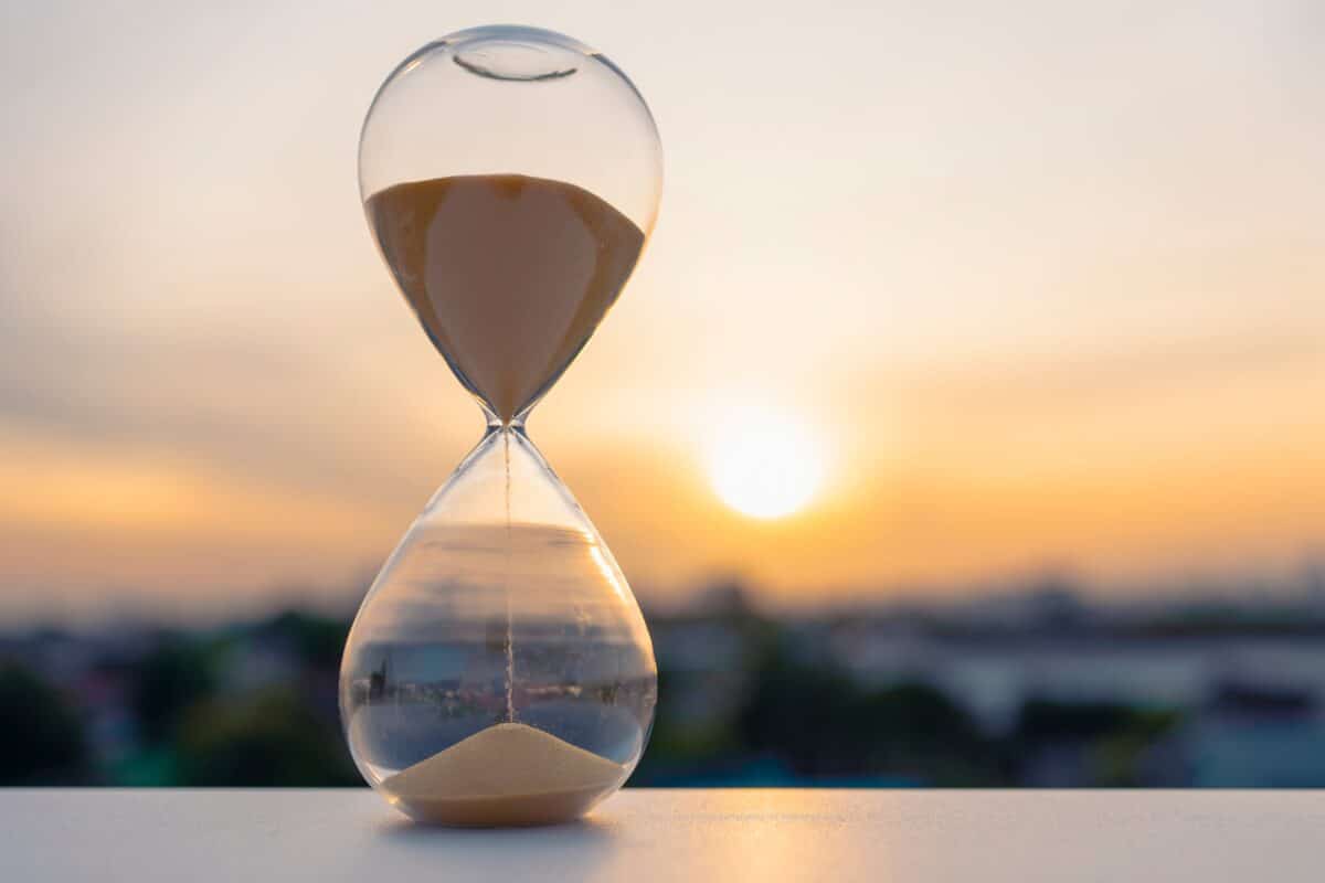 Hourglass,With,Golden,Sand,Flowing,At,Sunset,Symbolizing,The,End