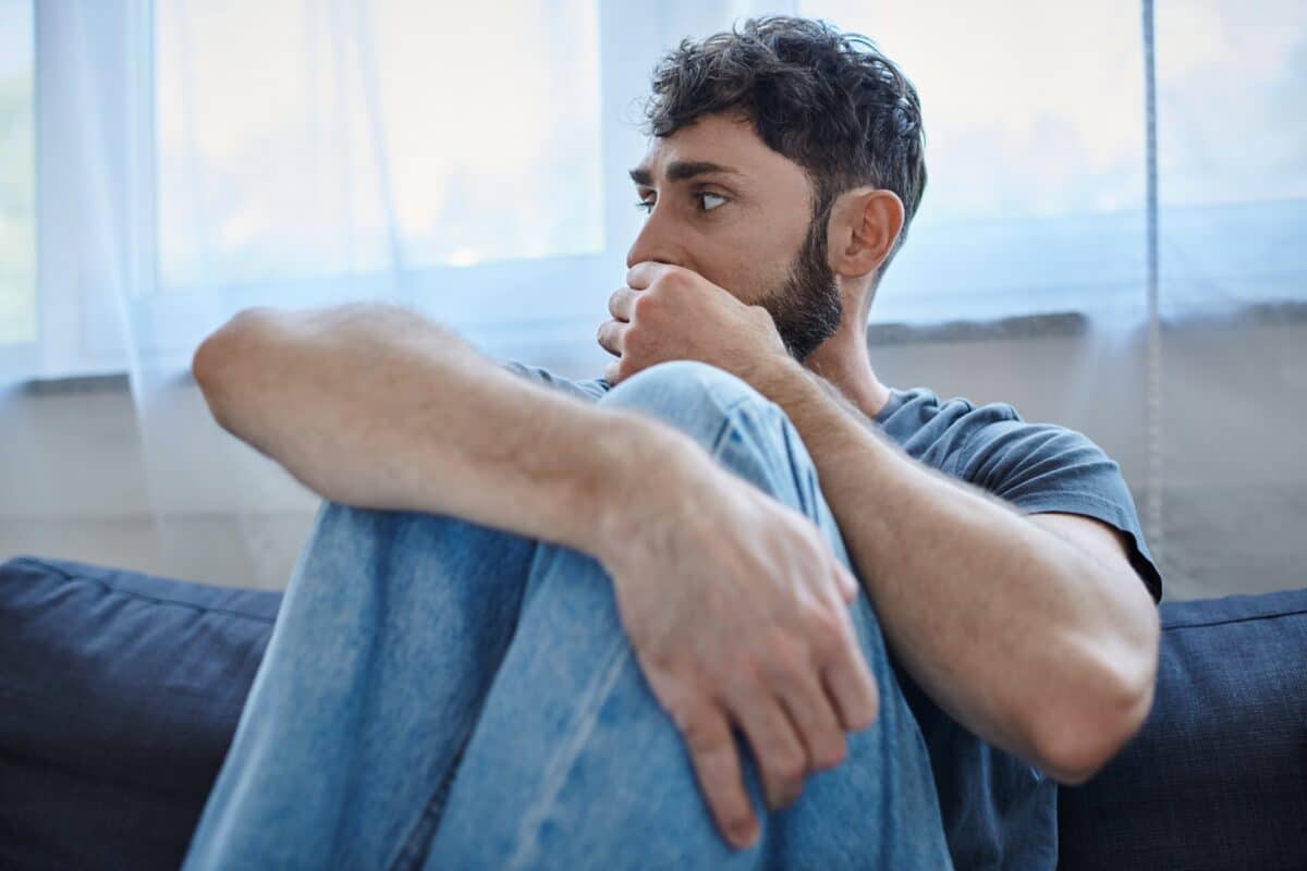 Traumatized,Anxious,Man,In,Casual,Clothes,Sitting,On,Sofa,During