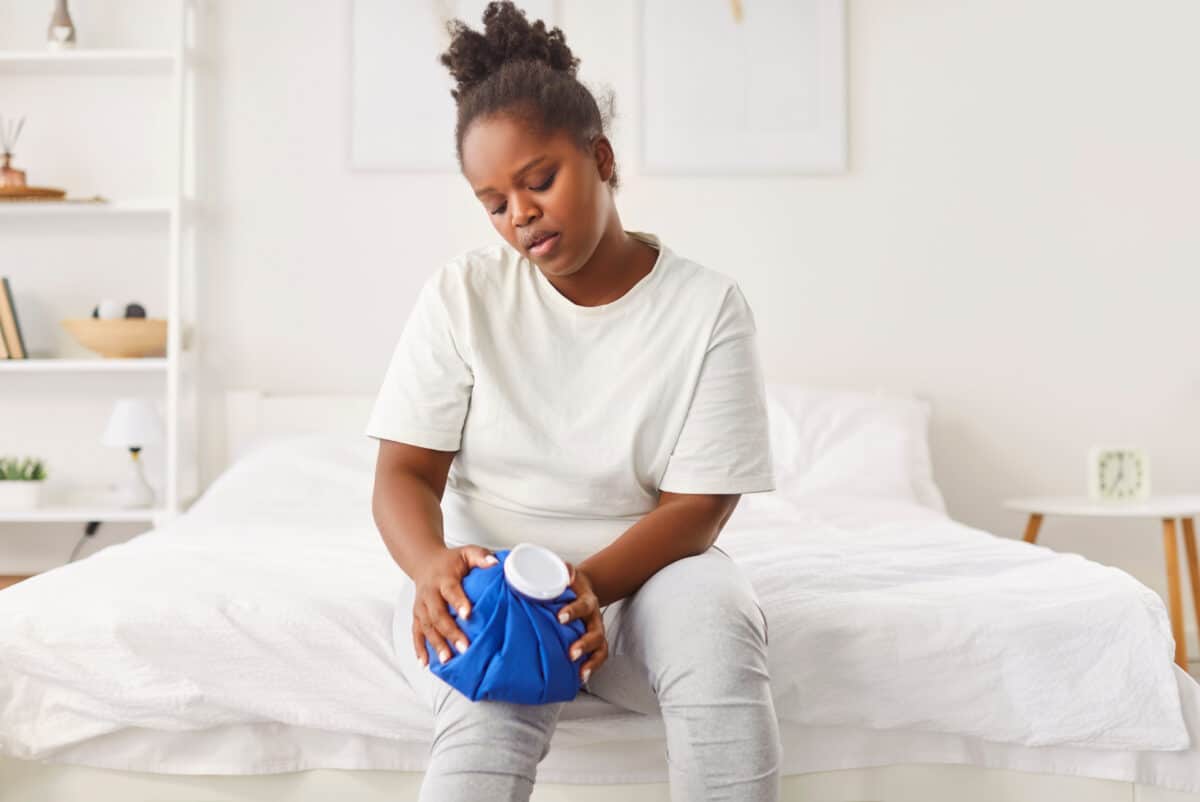 Woman putting ice pack on knee injury