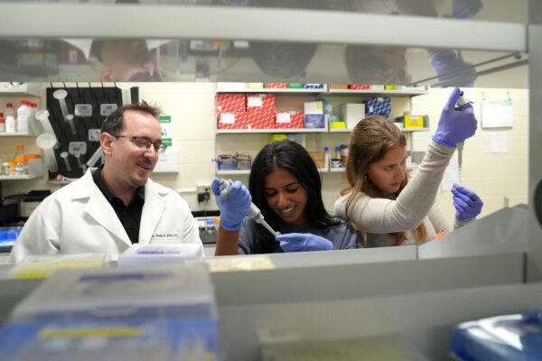 Professor Tim Jarome (at left) oversees two students working in his lab on memory disorder research.