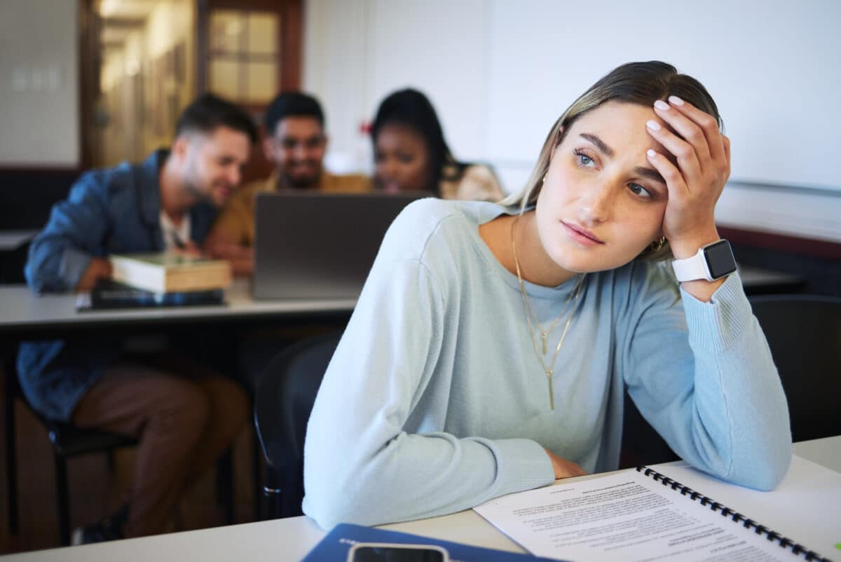 Stress, education and study with woman in classroom for exhausted, mental health and anxiety in college. Learning, books and exam with girl university student for fatigue, tired and burnout in school