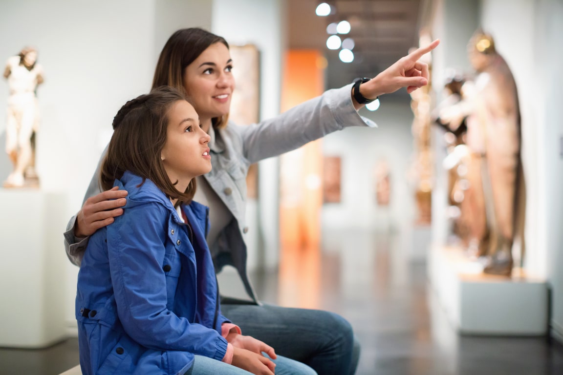Mother and daughter regarding ancient statues