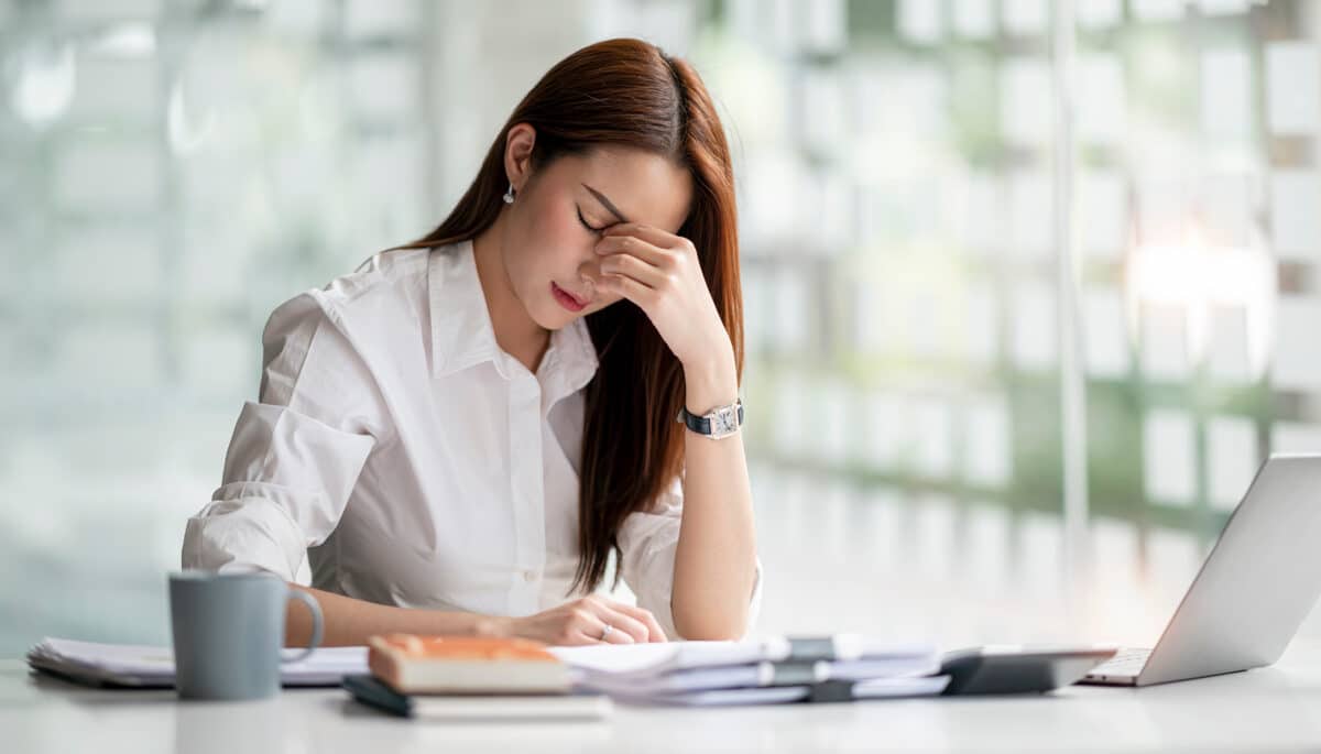 A stressed office worker has a headache