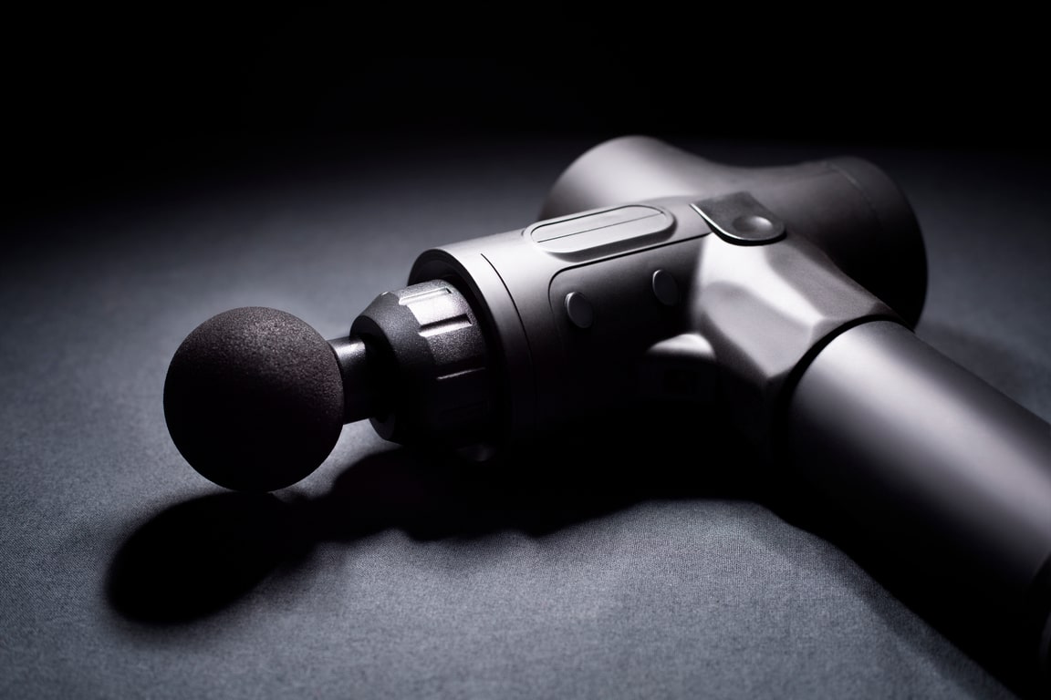 Percussion massager of deep muscle tissues for athletes, relaxes relieves pain. Handheld wireless professional therapeutic shock massage gun