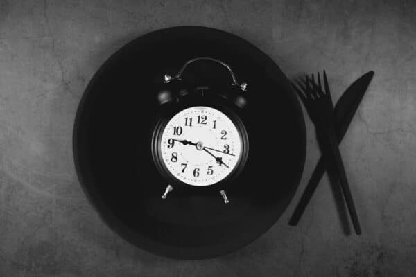 Intermittent fasting concept: Plate with an alarm clock on it