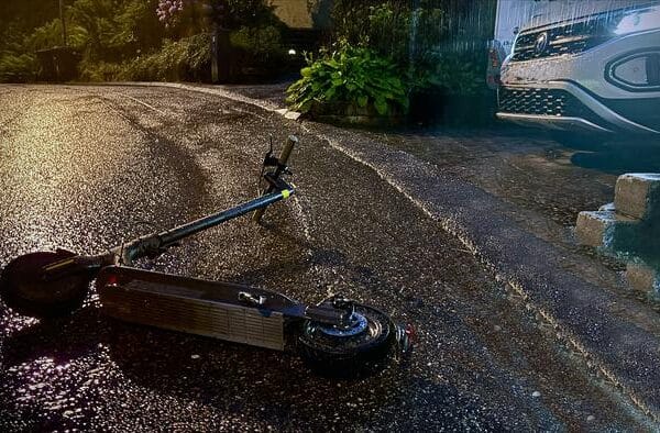 night picture of scooter laying on its side in the street